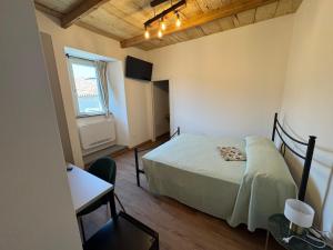 a bedroom with a bed and a desk and a window at Casa Guidi in Santa Sofia