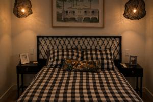 a bed with a black and white checkered blanket and pillows at Ebony & Ivory Villa in Nelson Bay