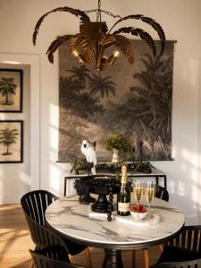 a dining room with a table with a chandelier at Ebony & Ivory Villa in Nelson Bay