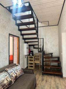 a living room with a spiral staircase and a couch at Білий птаха in Svityazʼ