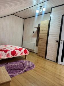 a bedroom with a bed and a wooden floor at Білий птаха in Svityazʼ +2 photos
