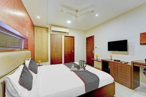 a bedroom with a bed and a flat screen tv at RG Suites - Royapettah in Chennai +18 photos