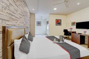 a bedroom with a large white bed and a desk at RG Suites - Royapettah in Chennai