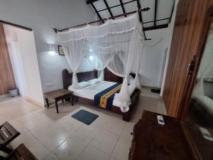a bedroom with a bed with a canopy at Ocean Haven in Induruwa