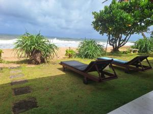 two chairs and a bench on the beach at Ocean Haven in Induruwa +12 photos