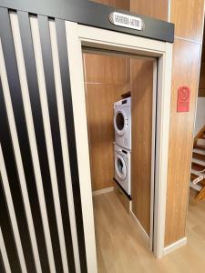 a door to a laundry room with a washer and dryer at As Baladas Hostel in Barro