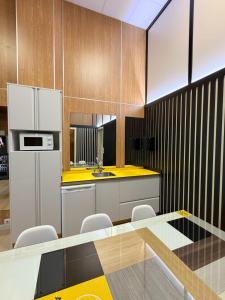 a kitchen with white appliances and a yellow counter top at As Baladas Hostel in Barro