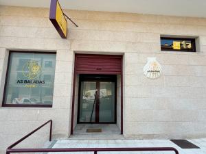 a entrance to a building with a glass door at As Baladas Hostel in Barro
