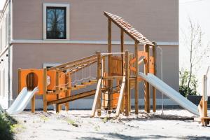 a playground with a slide in front of a building at Kaffeegarten Am Mühlwerder in Halle an der Saale