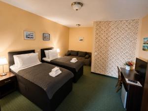a hotel room with two beds and a couch at Rooms Villa Iva in Ilok +97 photos