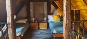 a small room with two beds in a attic at Duplex rénové avec terrasse privative à 10 mm de Colmar et Eguisheim, à 2 mm du grand axe autoroutier Strasbourg Mulhouse in Sainte-Croix-en-Plaine