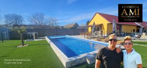 two men standing in front of a swimming pool at Panzio A mi Paradicsomunk in Véménd