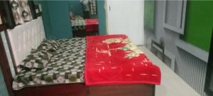 a room with a bed with a red blanket on it at Eighty eight restaurant and cafe in Muzaffarnagar