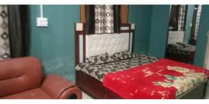 a bedroom with a bed and a chair in it at Eighty eight restaurant and cafe in Muzaffarnagar