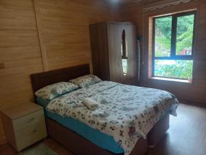 a bedroom with a bed in a wooden cabin at Ay Home Apart&bungalov in Uzungöl