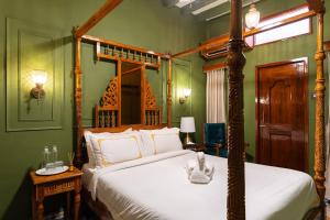 a bedroom with a bed with a wooden canopy at Hotel Palais De Versailles in Pondicherry
