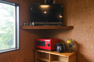 a red microwave sitting on a table next to a tv at Saunalodge 白道 in Minami Uonuma