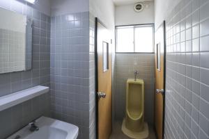 a bathroom with a urinal and a sink and a toilet at Saunalodge 白道 in Minami Uonuma