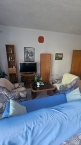 a living room with two beds and a tv at House Peri in Trogir