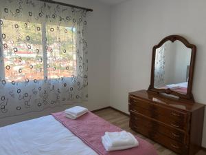 a bedroom with a mirror and a dresser with towels at LakeView Pogradec in Pogradec +4 photos