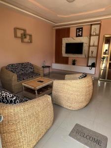 a living room with two couches and a television at Résidence Saint Gall-H in Ouidah