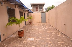 a walkway with a potted plant next to a building at Résidence Saint Gall-H in Ouidah