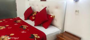 a bedroom with red pillows on a bed at Laya Neem Resort in Dambulla +6 photos