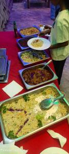 a long table with many plates of food on it at Laya Neem Resort in Dambulla