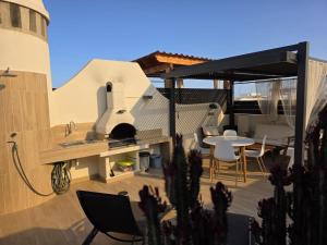 a patio with a pizza oven and a table and chairs at ÁTICO TERESA BORA PALM, PISCINA PRIVADA CLIMATIZABLE 250m playa in Vera