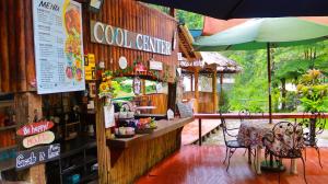 a coffee shop with a table and an umbrella at Pulangbato Falls Mountain Resort in Dumaguete