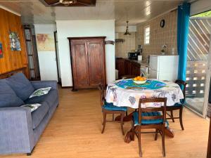 a living room with a table and a couch at Le petit meublé des hauts in Grande Ravine
