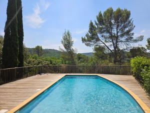 a swimming pool with a wooden walkway next to a wooden deck at Appartement Belle Vue in Gréoux-les-Bains +13 photos