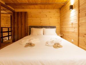 a bedroom with a bed with towels and slippers at Green Olive Luxury Villas in Paliouri