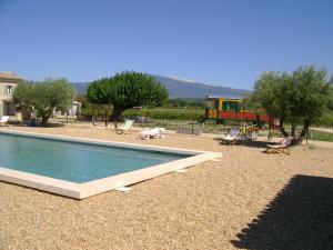 a swimming pool in a yard with trees and a house at La Grange de Campaulise - Camping à la ferme - Hébergements - Mont Ventoux in Mazan