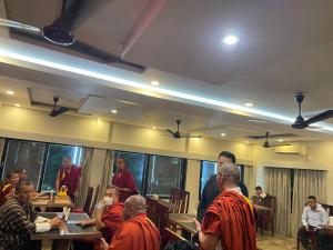 Eine Gruppe Mönche sitzt in einem Raum in einem Tempel in der Unterkunft Hotel Damchen in Phuentsholing