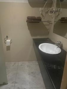 ein Badezimmer mit schwarzem Waschbecken und Toilette in der Unterkunft Hotel Damchen in Phuentsholing