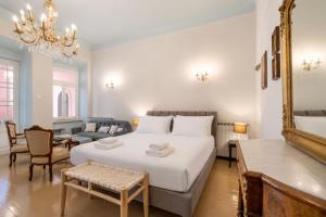 a bedroom with a large white bed and a living room at Neoclassical Mansion in Andros Town by Explore Andros in Andros