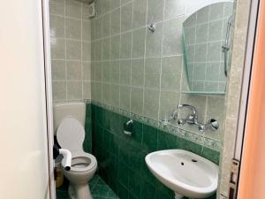 a green tiled bathroom with a toilet and a sink at Guest House Dayana Double Room 6 in Ravda