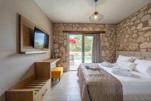 a bedroom with a bed and a desk and a tv at Τilevoides Nisi Villas in Spartokhórion +30 photos