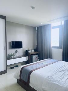 a bedroom with a bed and a flat screen tv at Thach An Hotel in Ðông Khê