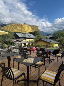 a group of tables and chairs with umbrellas on a deck at Thurners Boutique Hotel at Großglockner, Film Inspired in Bruck an der Großglocknerstraße