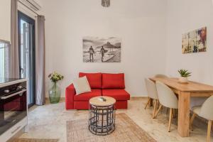 a living room with a red couch and a table at Grimihome 2 in Filiatra