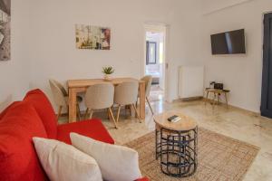 a living room with a red couch and a table at Grimihome 2 in Filiatra