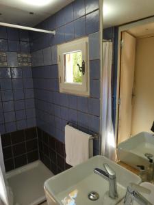 a blue tiled bathroom with a sink and a tub at La Roulotte in Arles +9 photos