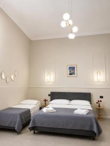 two beds in a room with white walls at IL Corso in Torre del Greco