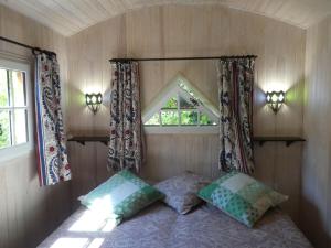 a small bedroom with a bed and a window at La Roulotte in Arles