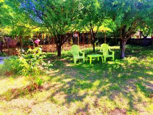 two chairs and a table in a yard with trees at Goranovi House in Pleven