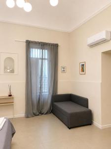 a living room with a couch in front of a window at IL Corso in Torre del Greco +5 photos