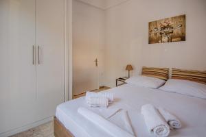 a bedroom with a white bed with towels on it at Grimihome 2 in Filiatra