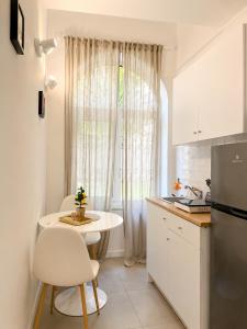 a white kitchen with a table and a window at IL Corso in Torre del Greco
